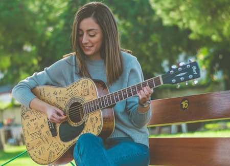 Female Guitarist Playing Acoustic Guitar