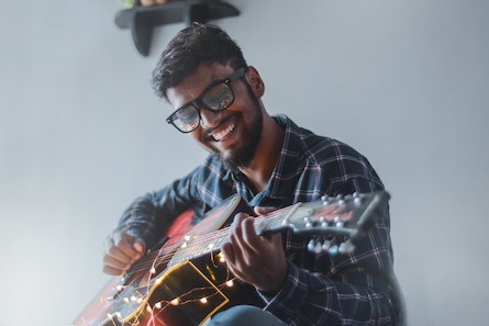 Female Guitarist Playing Acoustic Guitar