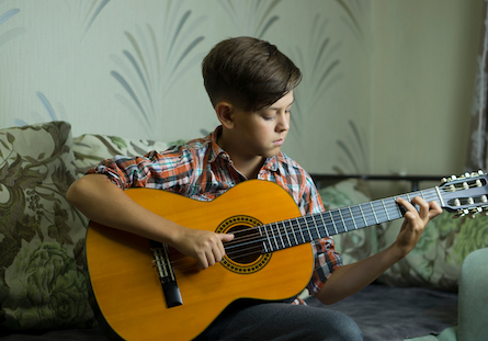 Boy Playing the Classical Guitar at Home